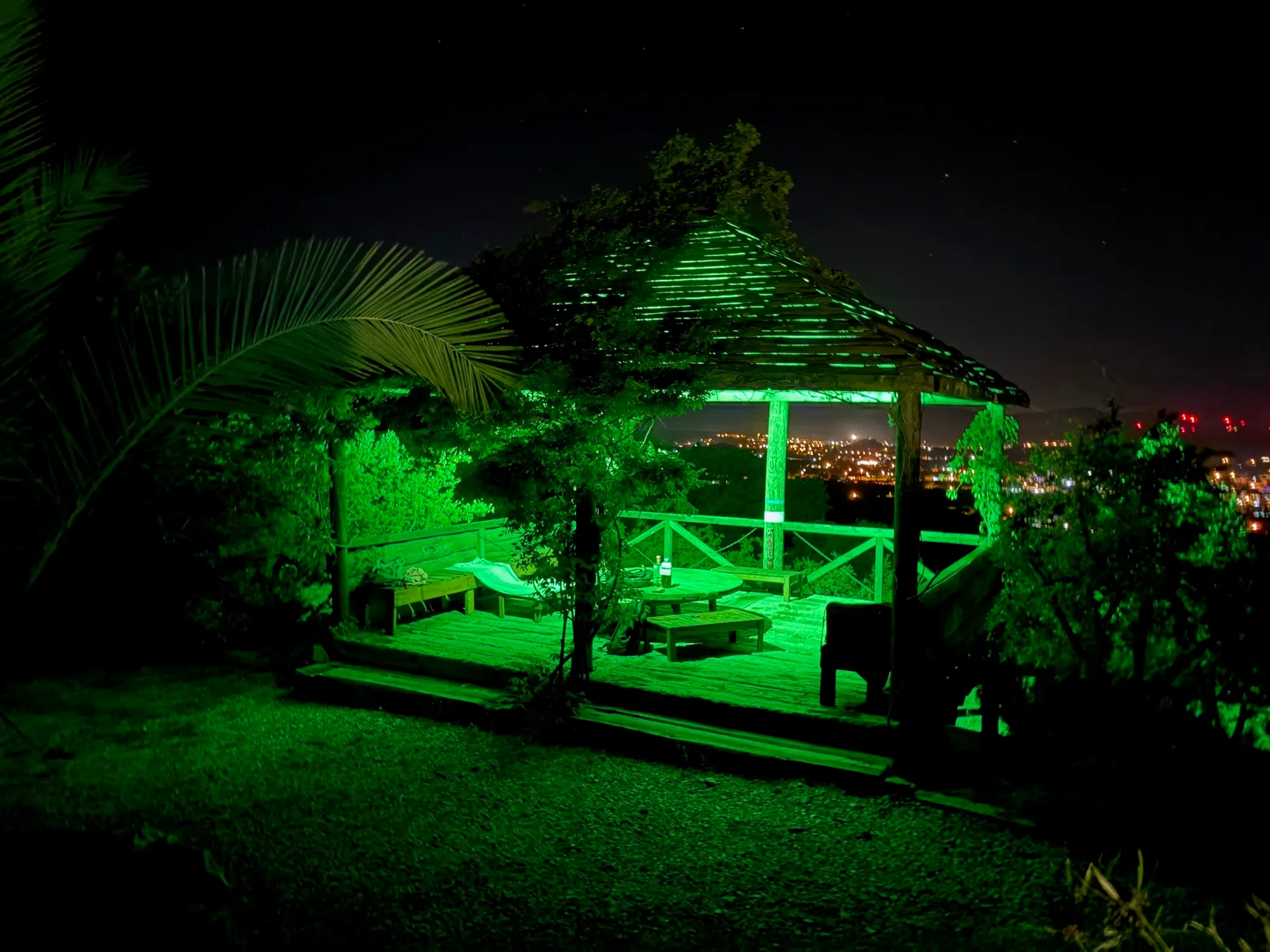 The gazebo lit green at night